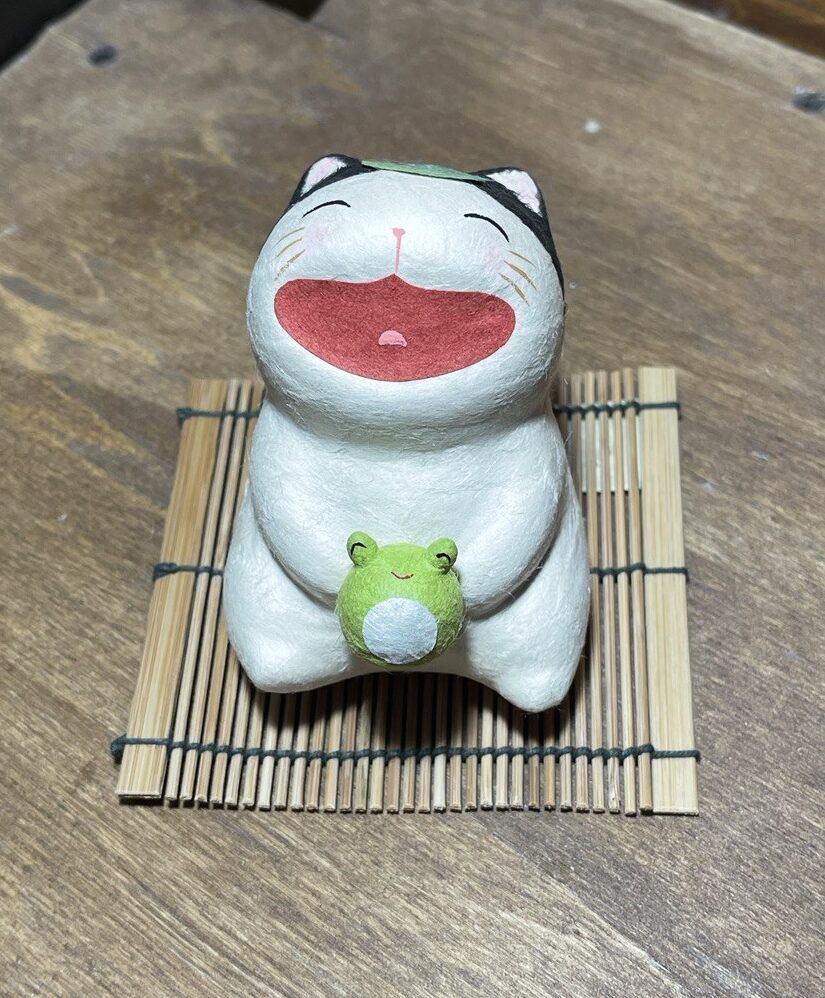 gatto sorridente con rana